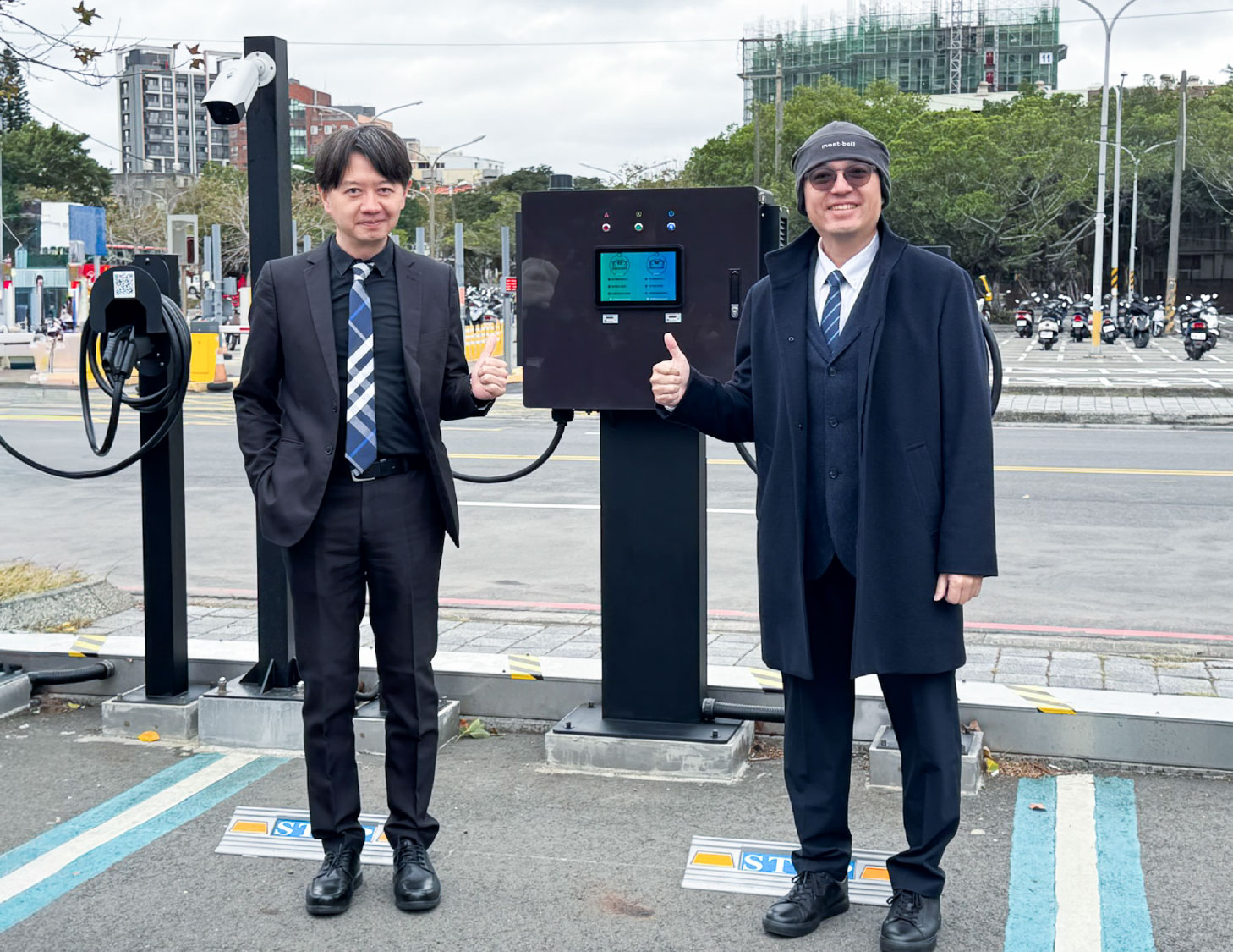 遠傳電信協理張文津與起而行綠能董事長簡金品於充電樁前合影